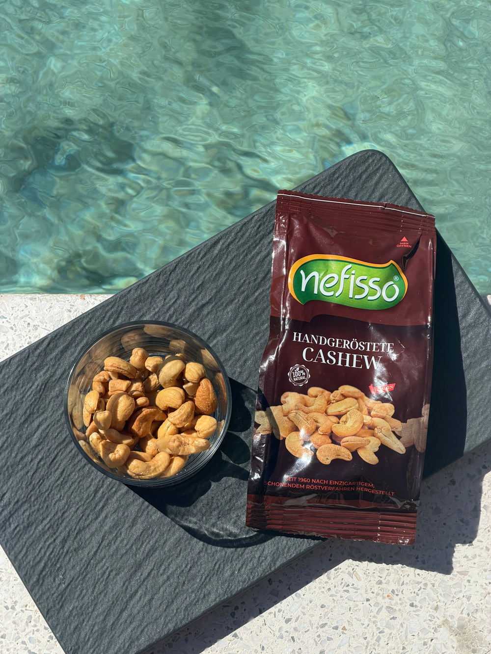 Nefisso Cashews und eine Schale Cashewnüsse am Pool