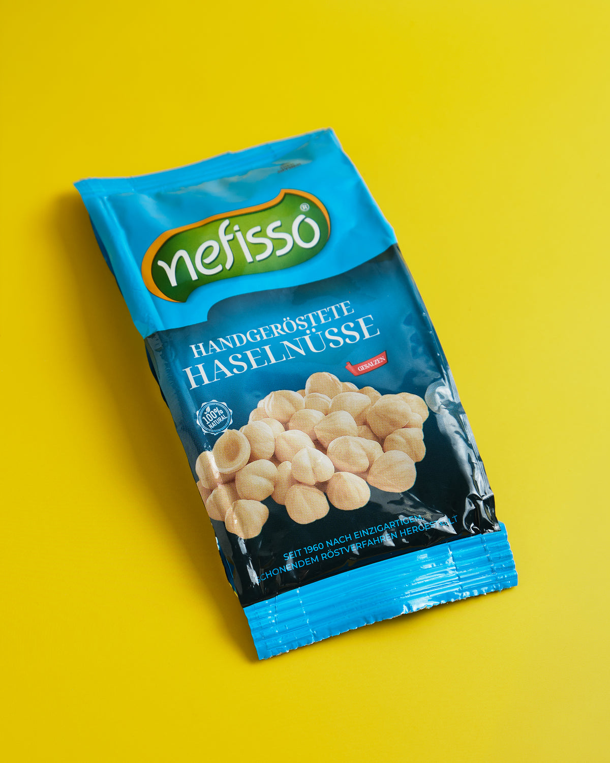 Nefisso Haselnüsse in blauer Verpackung auf gelbem Hintergrund